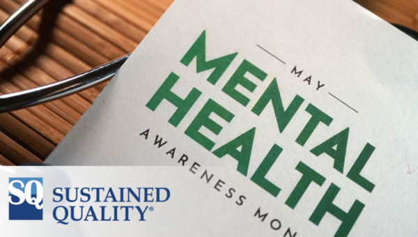 closeup of paper on desk that reads May Mental Health Awareness Month